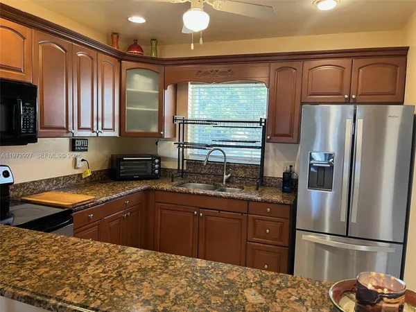a kitchen with stainless steel appliances granite countertop a refrigerator stove and sink