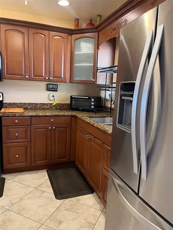 a kitchen with stainless steel appliances granite countertop a refrigerator and a sink