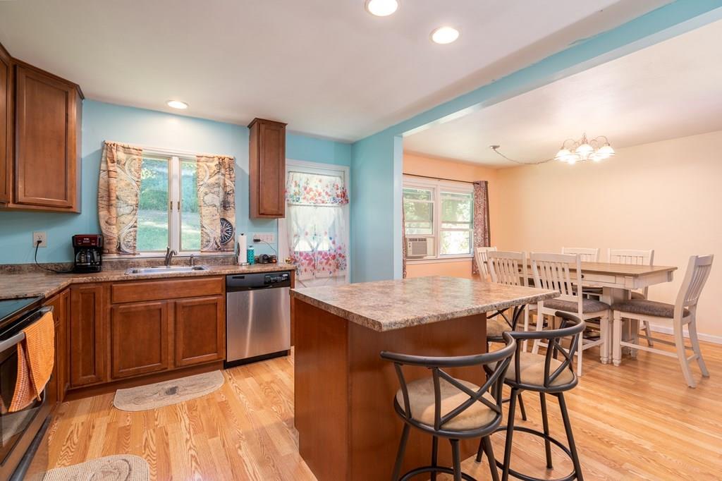 717 Florence Road Northampton, MA 01062 - Photo 5 of 27 a dining hall with stainless steel appliances granite countertop a stove a sink a dining table and chairs with wooden floor