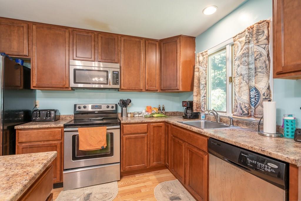 717 Florence Road Northampton, MA 01062 - Photo 6 of 27 a kitchen with stainless steel appliances granite countertop wooden cabinets a stove a sink and a microwave