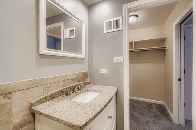 a bathroom with a granite countertop sink and a mirror
