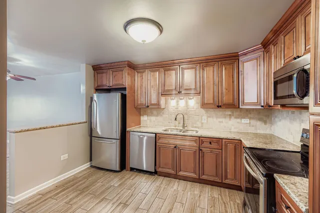 a kitchen with granite countertop a refrigerator stove top oven and sink