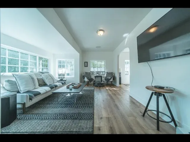 a living room with furniture and a wooden floor