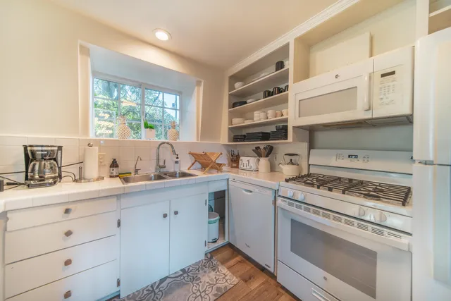 a kitchen with cabinets appliances and a window