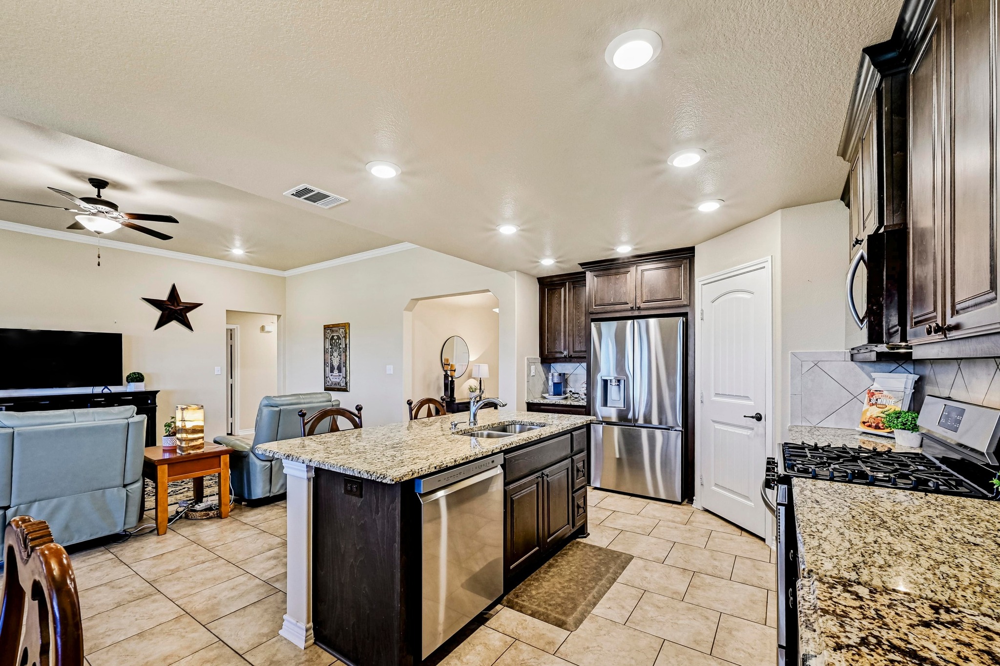 560 Saddle Ridge Drive Bertram, TX 78605 - Photo 26 of 27 a kitchen with stainless steel appliances granite countertop a sink stove and refrigerator