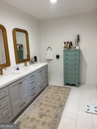 a spacious bathroom with a double vanity sink and mirror