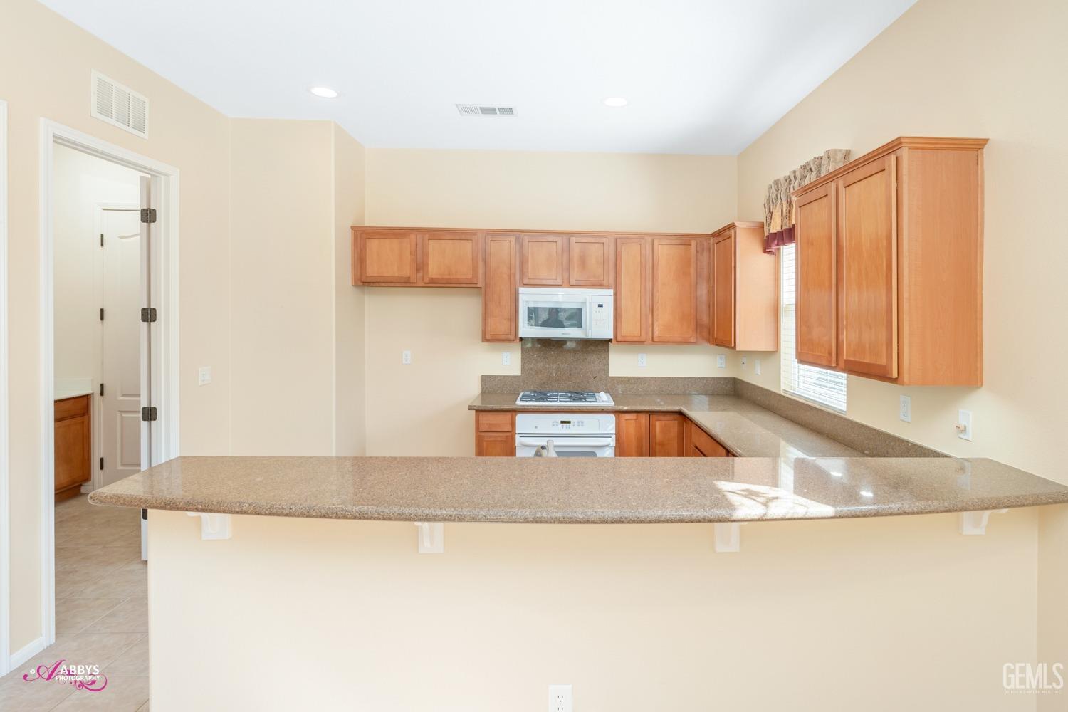 Undisclosed Address Bakersfield, CA 93306 - Photo 11 of 51 a kitchen with a refrigerator a sink and a cabinets