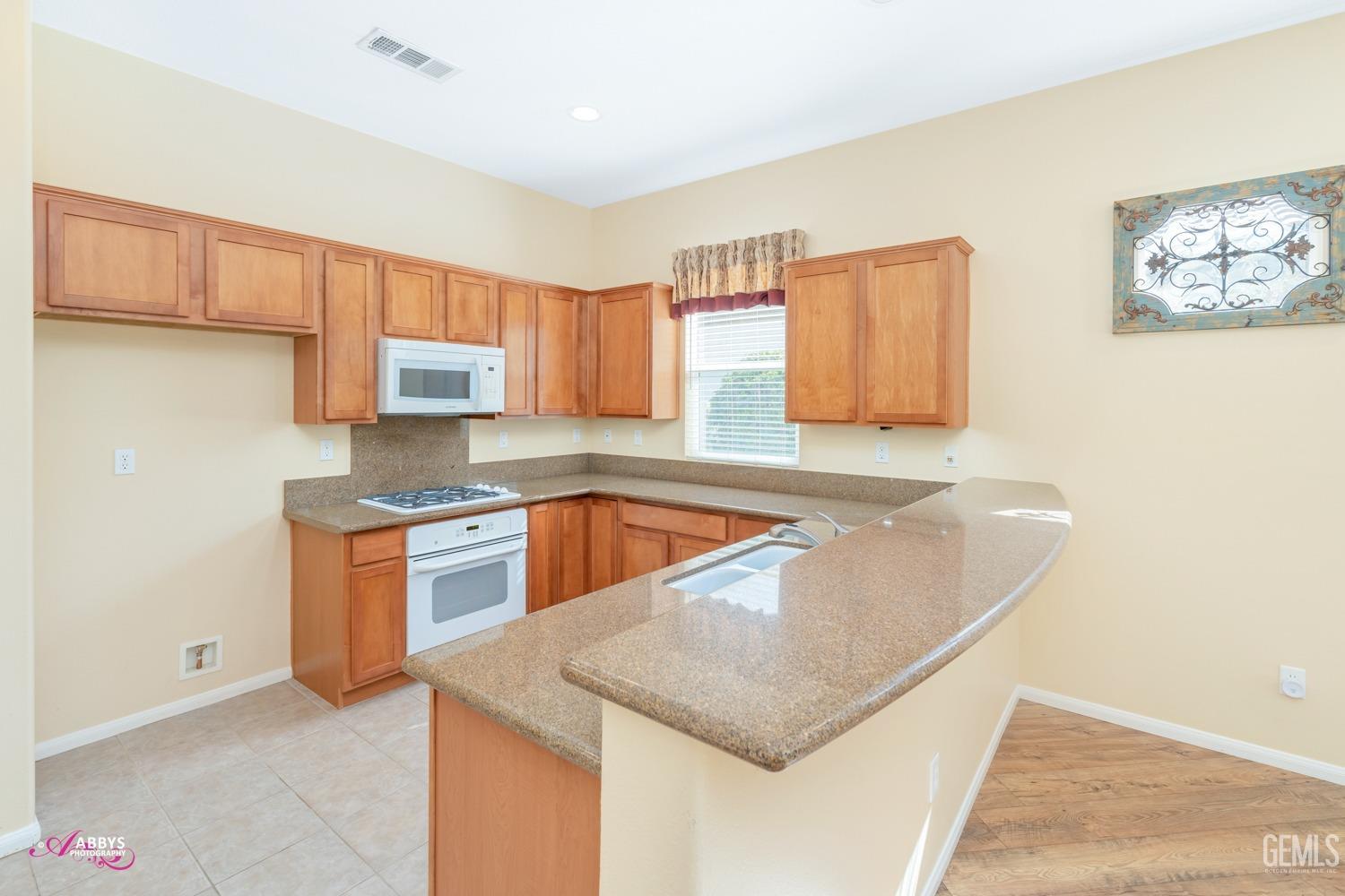 Undisclosed Address Bakersfield, CA 93306 - Photo 12 of 51 a kitchen with stainless steel appliances granite countertop a sink a stove and a refrigerator