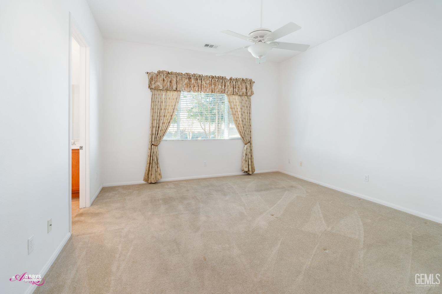 Undisclosed Address Bakersfield, CA 93306 - Photo 18 of 51 an empty room with a window and a ceiling fan