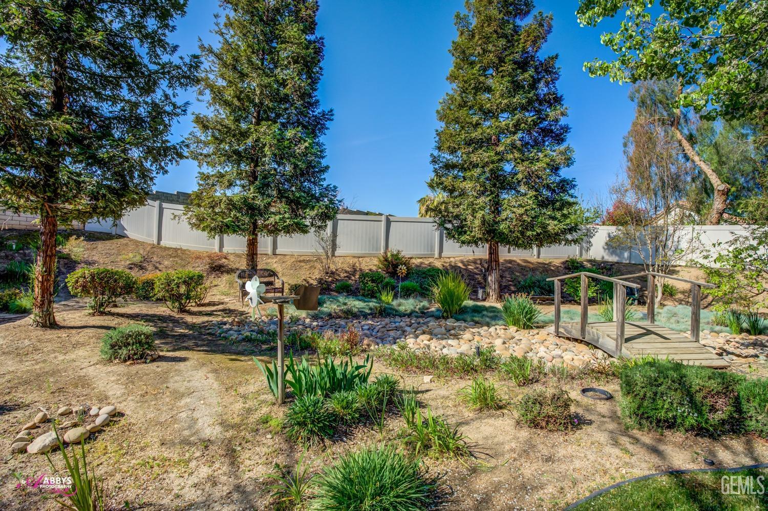 Undisclosed Address Bakersfield, CA 93306 - Photo 27 of 51 a view of a yard with plants and large trees