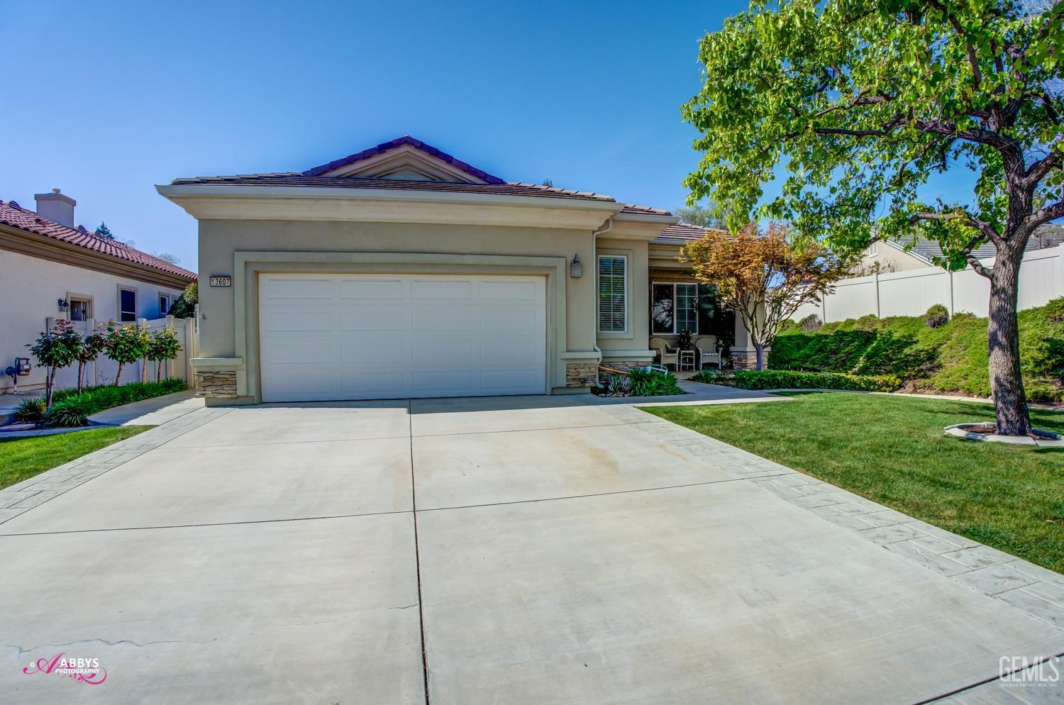 Undisclosed Address Bakersfield, CA 93306 - Photo 4 of 51 a front view of a house with a yard and garage