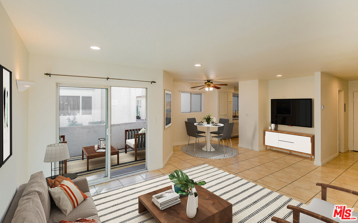 7651 Reseda Boulevard, Unit 3T Reseda, CA 91335 - Photo 14 of 32 a living room with furniture a flat screen tv and kitchen view