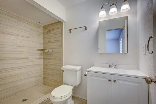 a bathroom with a toilet a sink a shower and mirror