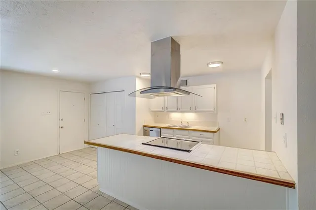 a kitchen with granite countertop a stove and a white cabinets