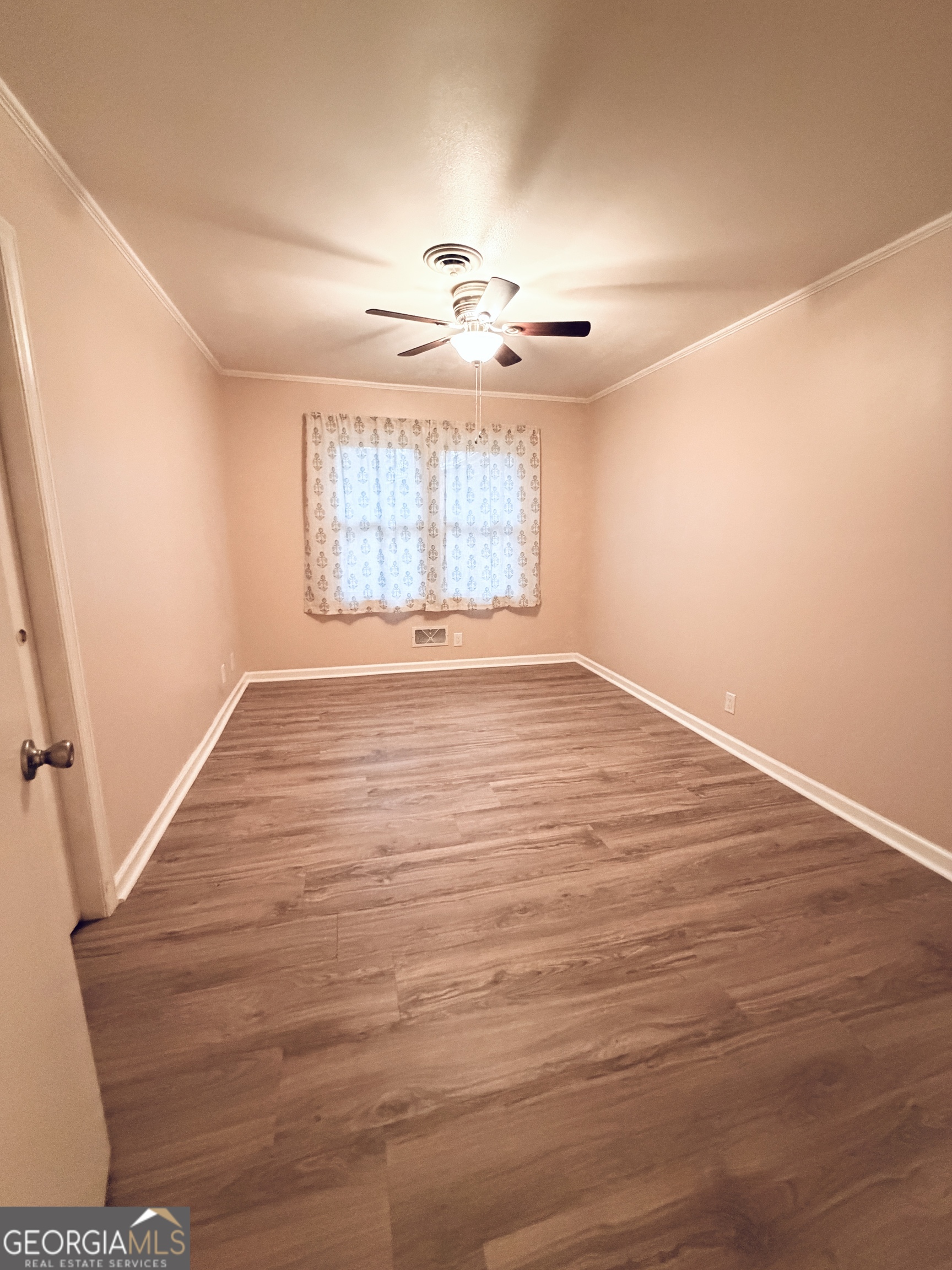 1701 Cedarwood Road Milledgeville, GA 31061 - Photo 22 of 40 an empty room with wooden floor and windows