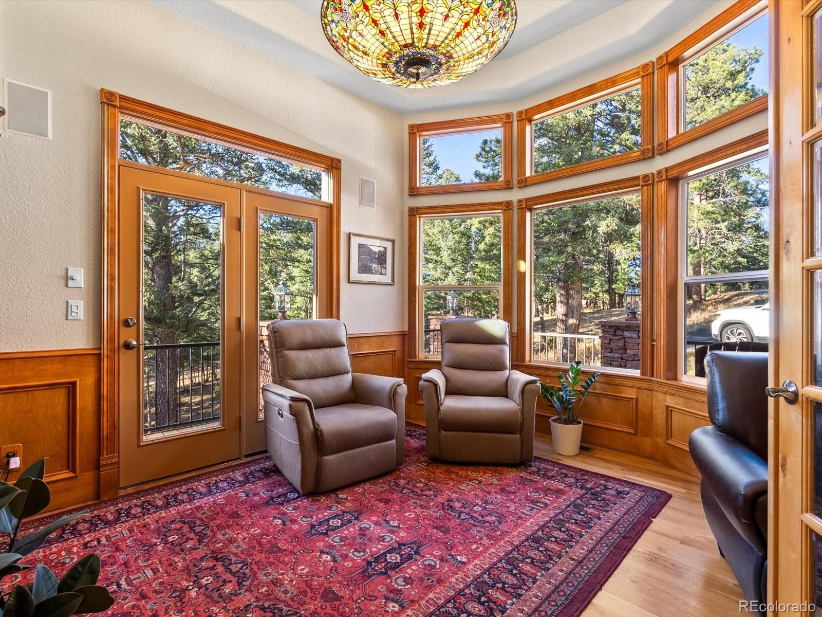 20906 Horse-Bit Way Morrison, CO 80465 - Photo 8 of 49 a living room with furniture large windows and wooden floor