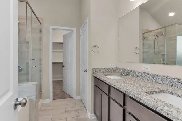 a bathroom with a granite countertop sink and shower