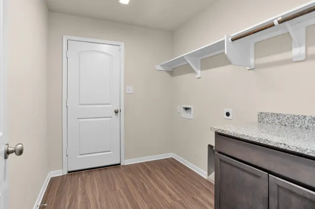 a view of a storage and utility room with wooden floor
