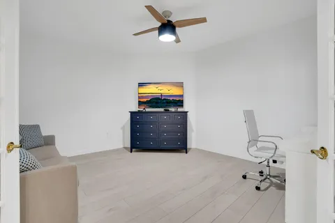 a living room with furniture and a ceiling fan