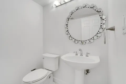 a bathroom with a sink toilet and mirror