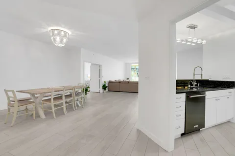 a kitchen with a dining table chairs and wooden floor