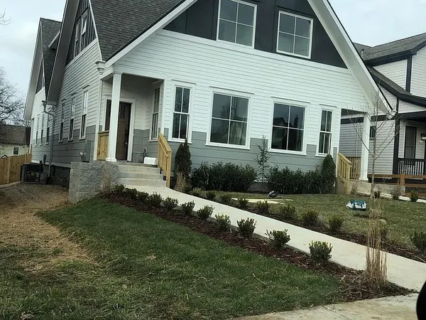 a kitchen with stainless steel appliances kitchen island granite countertop a stove a sink a refrigerator a dining table and chairs with wooden floor