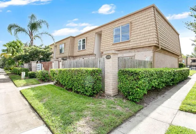 a view of backyard of house with potted plants