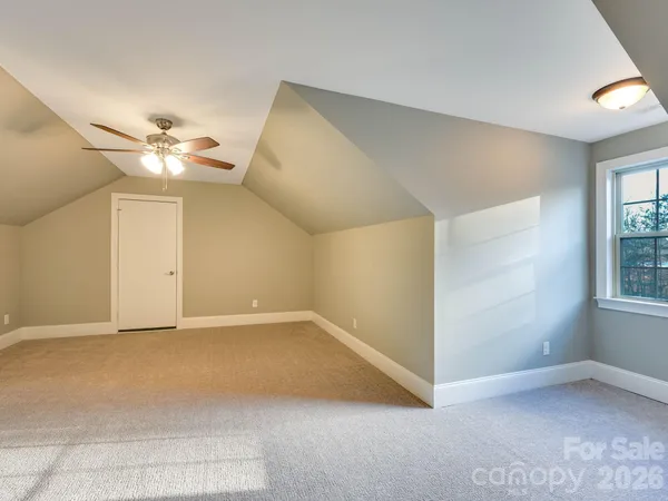 an empty room with windows and ceiling fan
