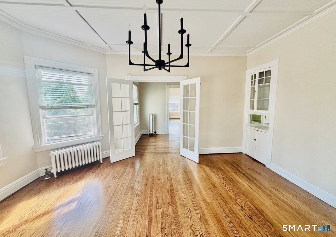 142 Broad Street Norwich, CT 06360 - Photo 11 of 26 a view of an empty room with wooden floor and a window