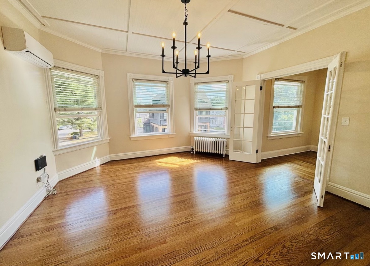 142 Broad Street Norwich, CT 06360 - Photo 12 of 26 a view of an empty room with wooden floor and a window