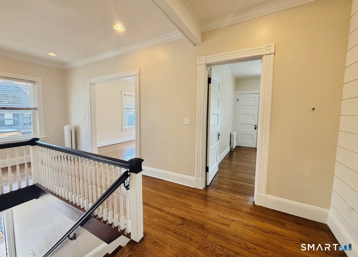 142 Broad Street Norwich, CT 06360 - Photo 13 of 26 a view of a hallway with wooden floor and stairs