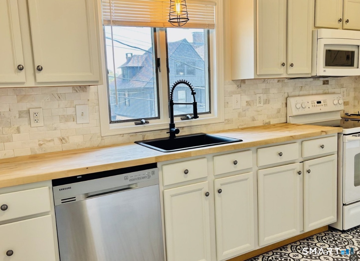 142 Broad Street Norwich, CT 06360 - Photo 4 of 26 a kitchen with granite countertop white cabinets and white appliances
