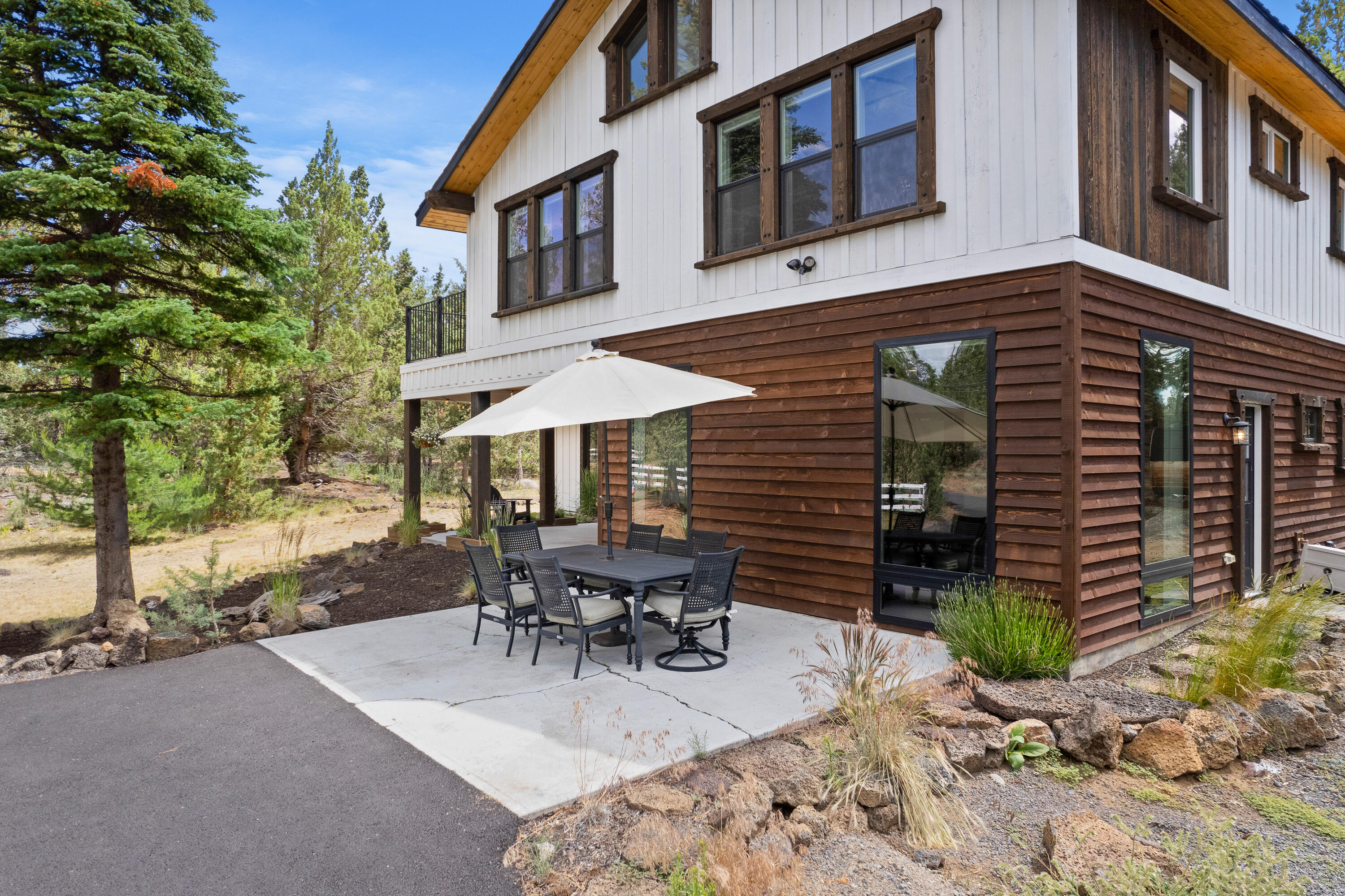 64732 Hunnell Road Bend, OR 97703 - Photo 38 of 51 a view of a patio with table and chairs under an umbrella