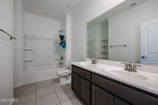 a bathroom with a double vanity sink toilet and shower