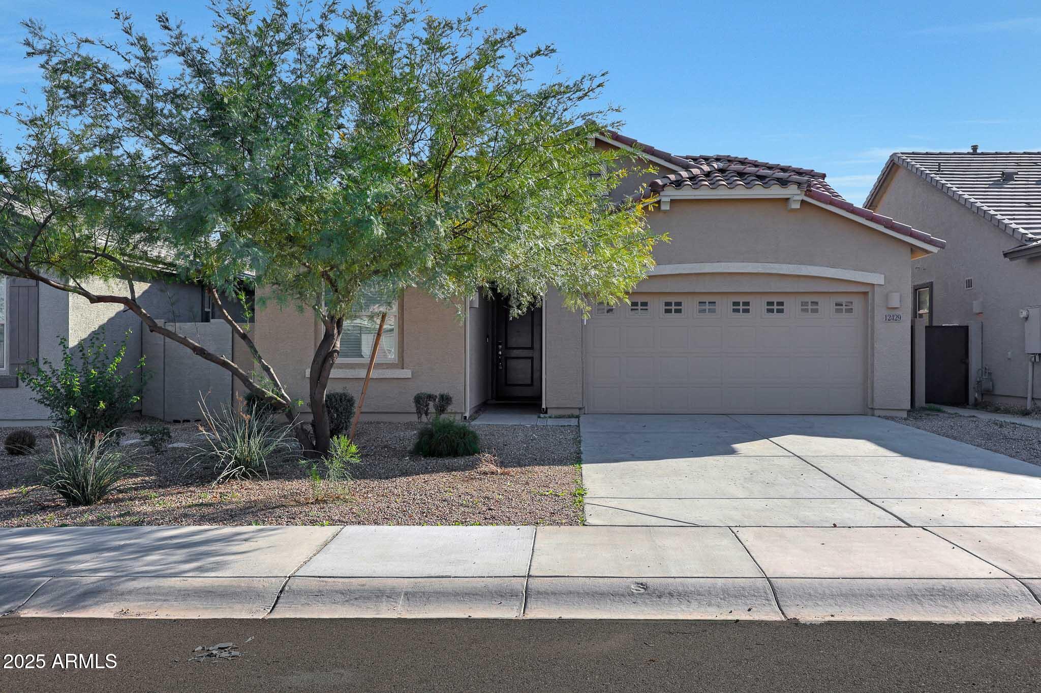 12429 West Midway Avenue Glendale, AZ 85307 - Photo 2 of 22 a front view of a house with garage and plants