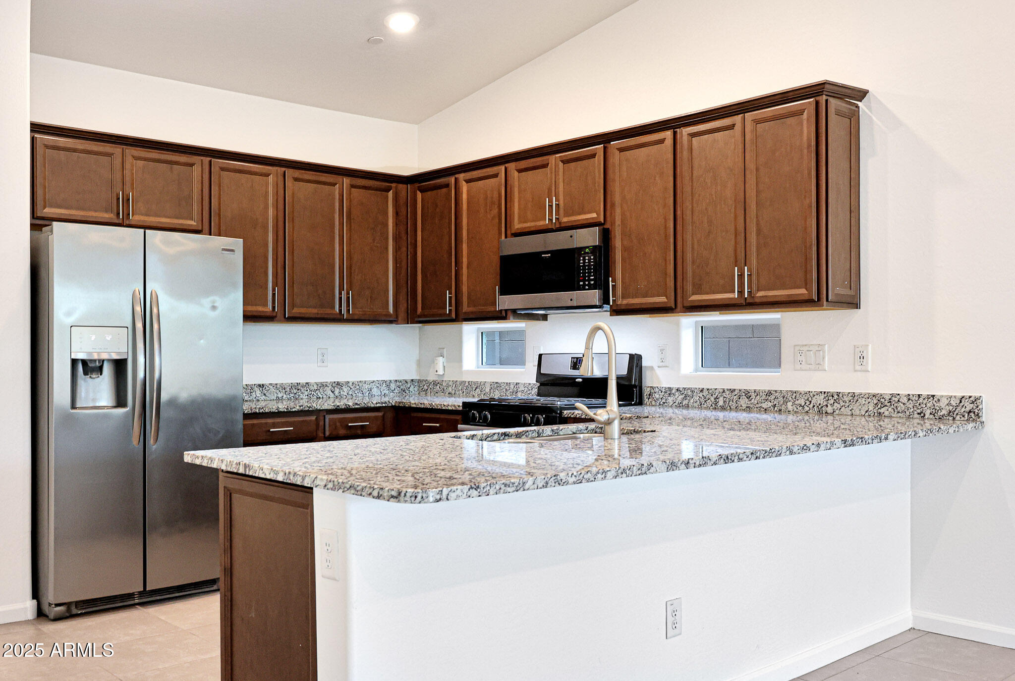 12429 West Midway Avenue Glendale, AZ 85307 - Photo 3 of 22 a kitchen with granite countertop a refrigerator sink and microwave