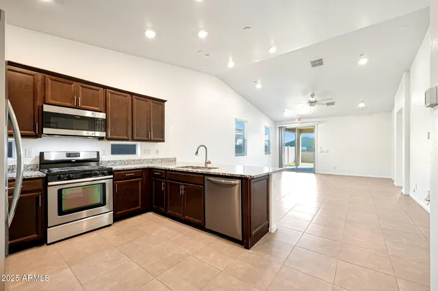 a large kitchen with stainless steel appliances granite countertop a stove and a sink