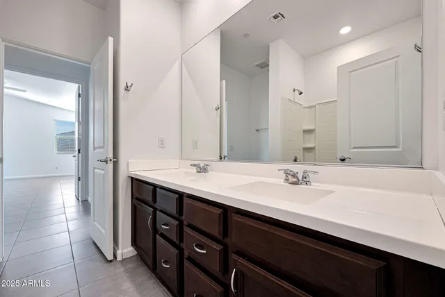 a bathroom with a double vanity sink a mirror and a bathtub