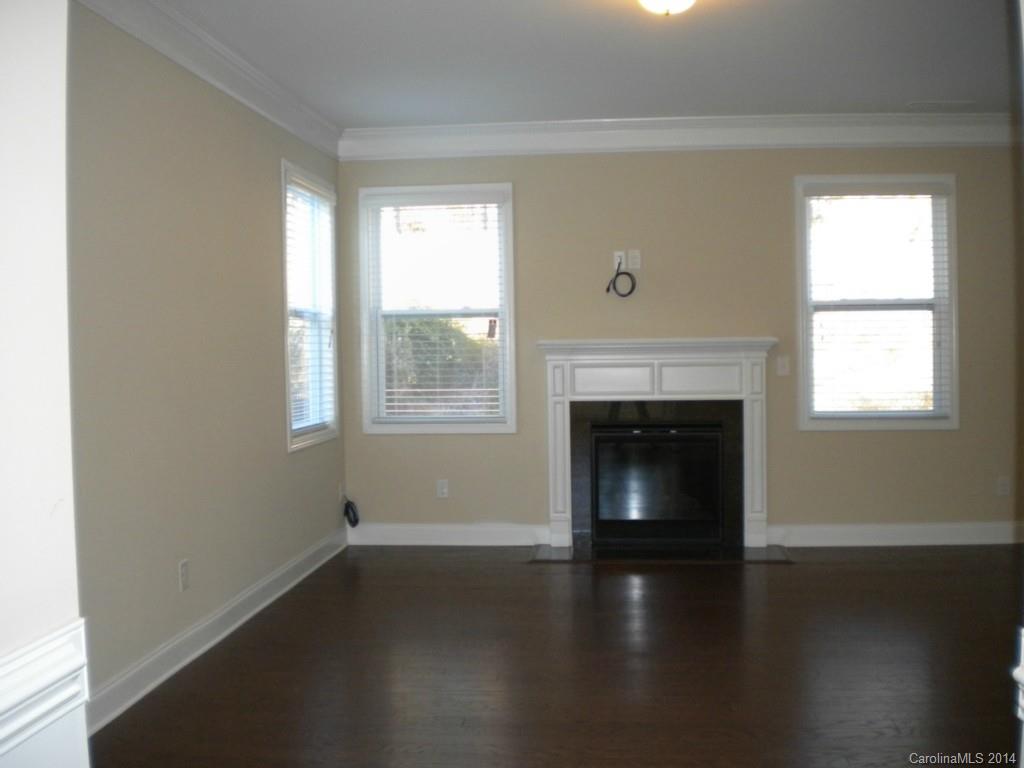 78074 Rillstone Drive, Unit 196 Lancaster, SC 29720 - Photo 6 of 24 an empty room with wooden floor fireplace and windows