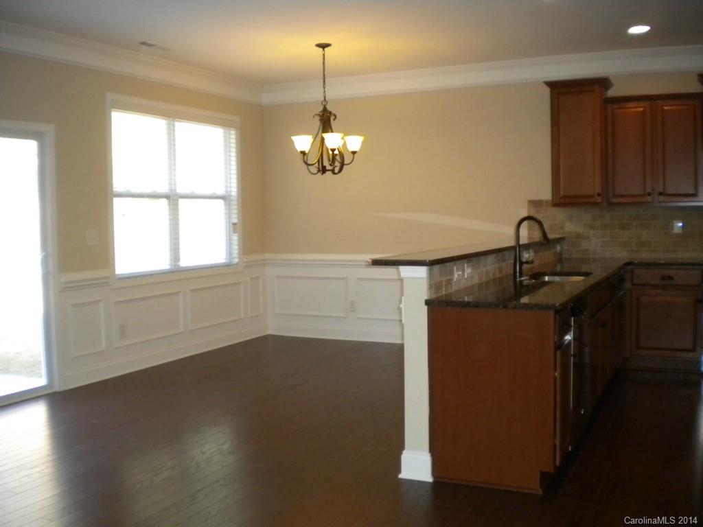 78074 Rillstone Drive, Unit 196 Lancaster, SC 29720 - Photo 8 of 24 a kitchen with granite countertop a sink cabinets and wooden floor