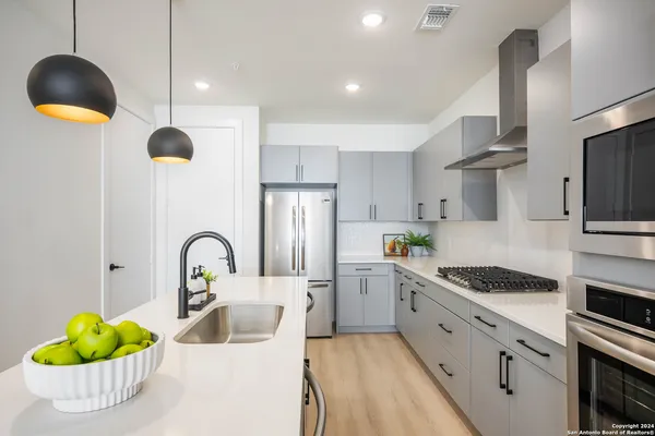 a kitchen with sink stove and cabinets