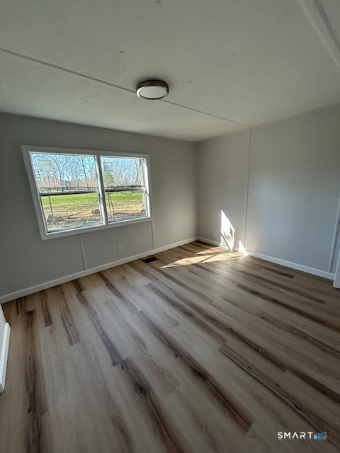 18 Fairway Drive Windham, CT 06256 - Photo 11 of 15 an empty room with wooden floor and windows