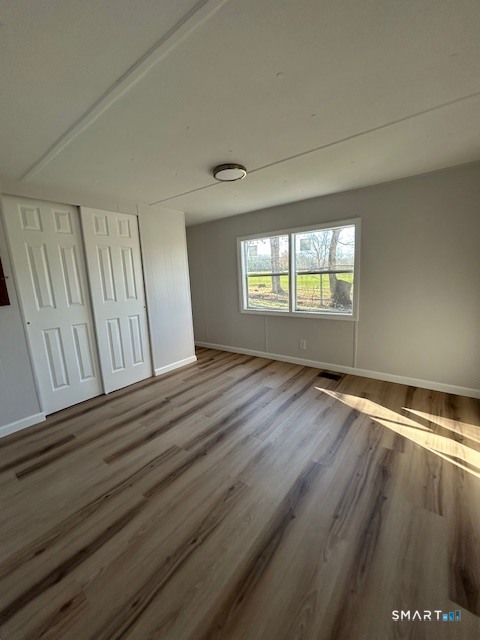 18 Fairway Drive Windham, CT 06256 - Photo 13 of 15 an empty room with wooden floor and windows