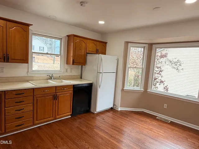 a kitchen with wooden floors and windows