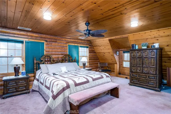 a bedroom with a bed a dresser and a walk in closet