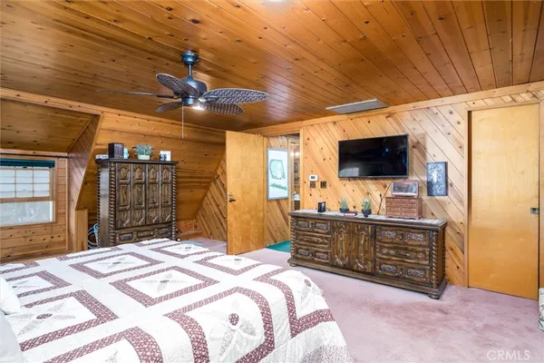 a spacious bedroom with a bed and a flat screen tv