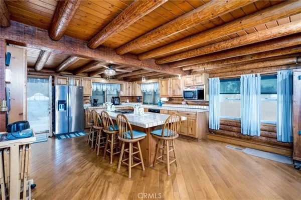 a dining room with stainless steel appliances wooden floors stove and white walls
