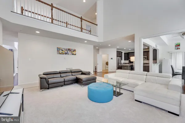 a living room with furniture and a view of kitchen