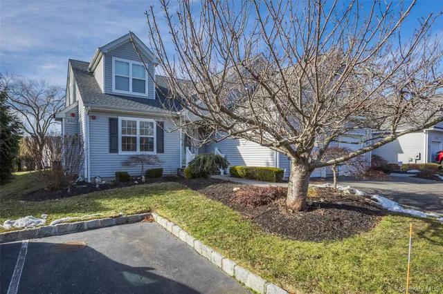 a front view of a house with a yard tree and outdoor seating