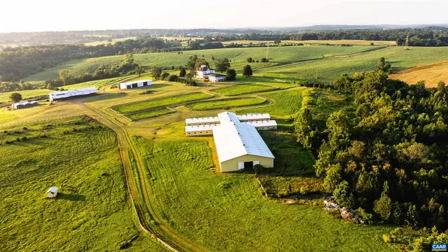 a view of a house with a big yard and large trees